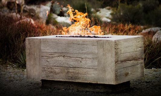 A fire pit in a fall setting with colorful autumn leaves and a warm, glowing fire, creating a cozy and inviting atmosphere.