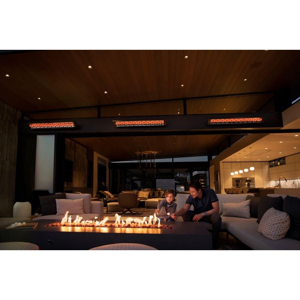 Two people sitting by a fire pit in a modern outdoor living space with visible infratech heaters.