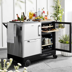 Outdoor kitchen cart with drinks and appliances on a patio