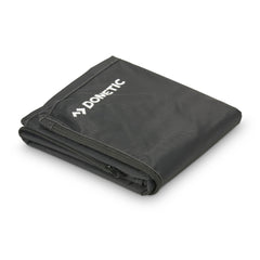 Folded black MOBAR Mobile Grill cover with Dometic logo on a white background